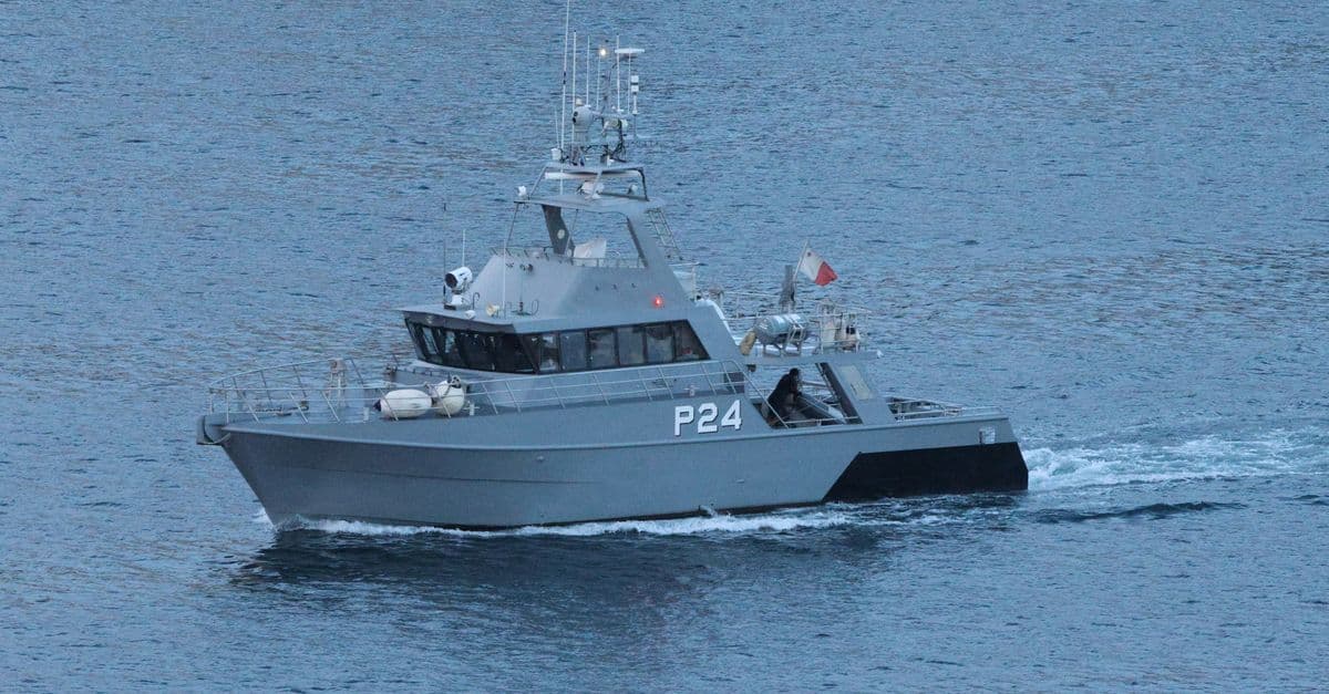 Military patrol boat cruising through ocean waters.