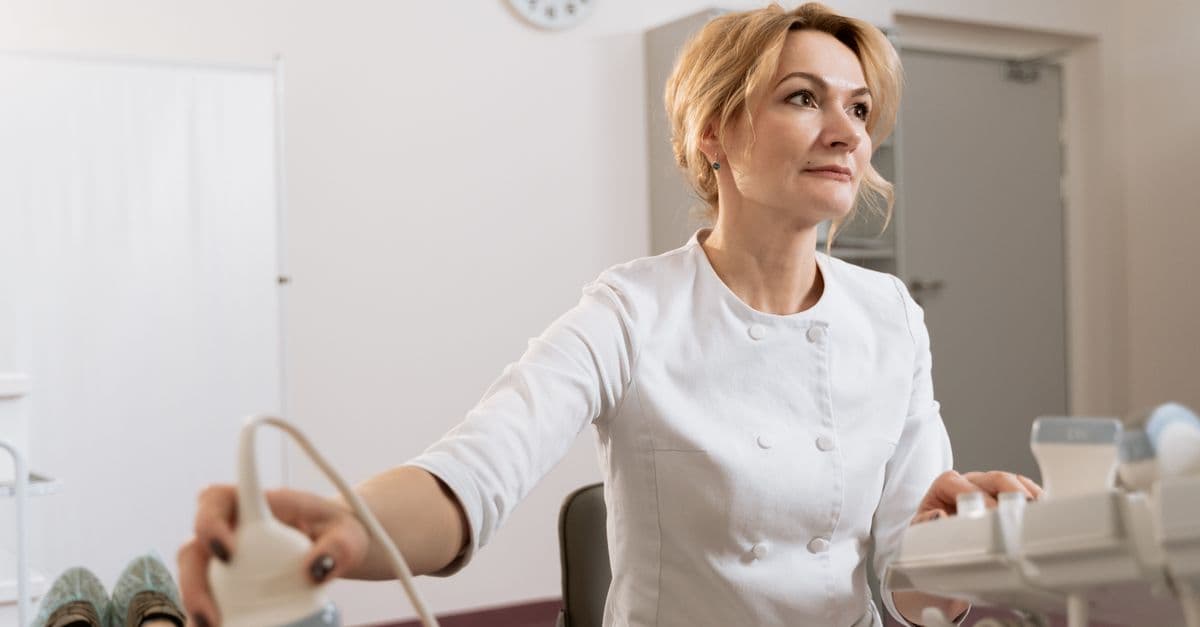 A female doctor performing an ultrasound in a medical clinic.