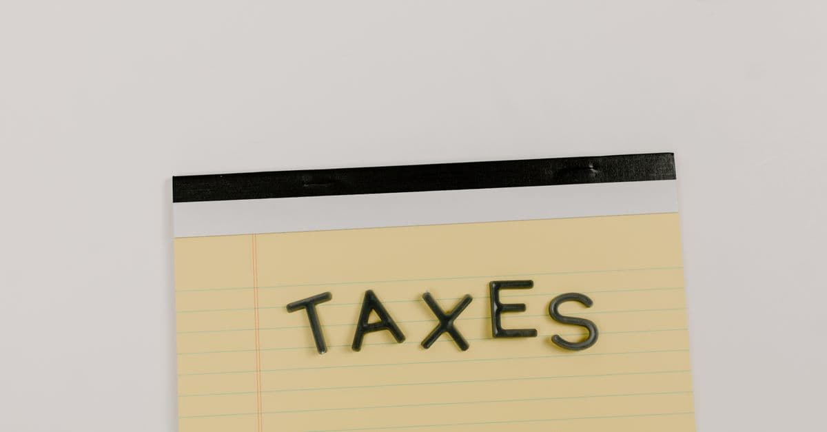 A flat lay of the word 'TAXES' on a yellow notepad, ideal for financial content.