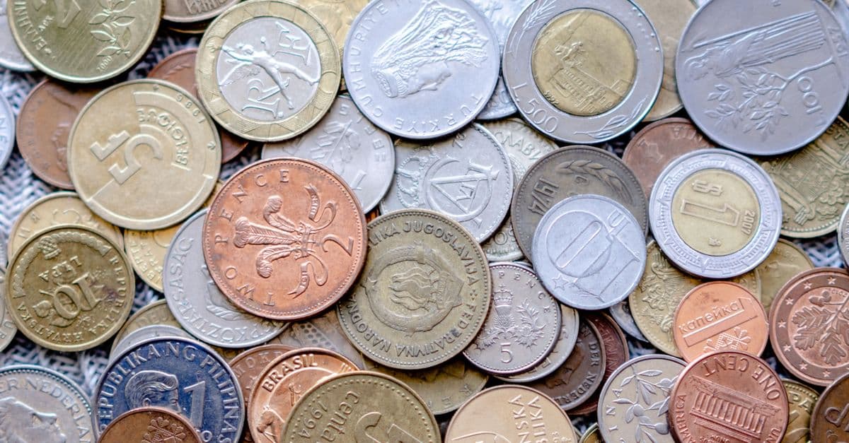 Colorful collection of international coins in various denominations and currencies.