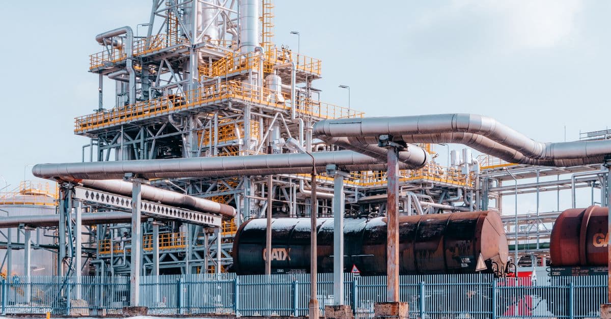 Oil refinery facility with tanker wagons in Trzebinia, Lesser Poland Voivodeship under a clear sky.