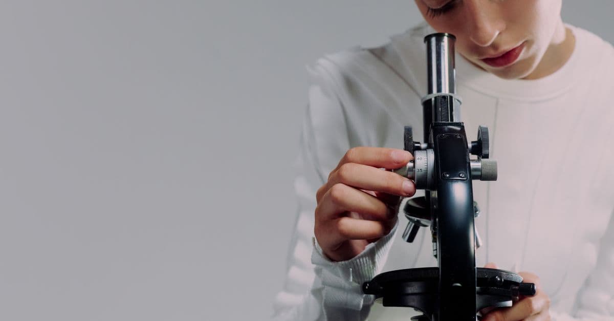 A scientist carefully examining samples using a microscope in a modern laboratory setting.