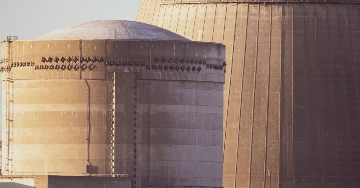 Close-up view of nuclear reactor buildings bathed in golden light, showcasing industrial architecture.