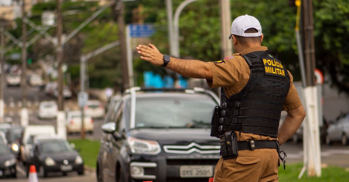 Police officer directing traffic on a busy street in Londrina, Brazil.