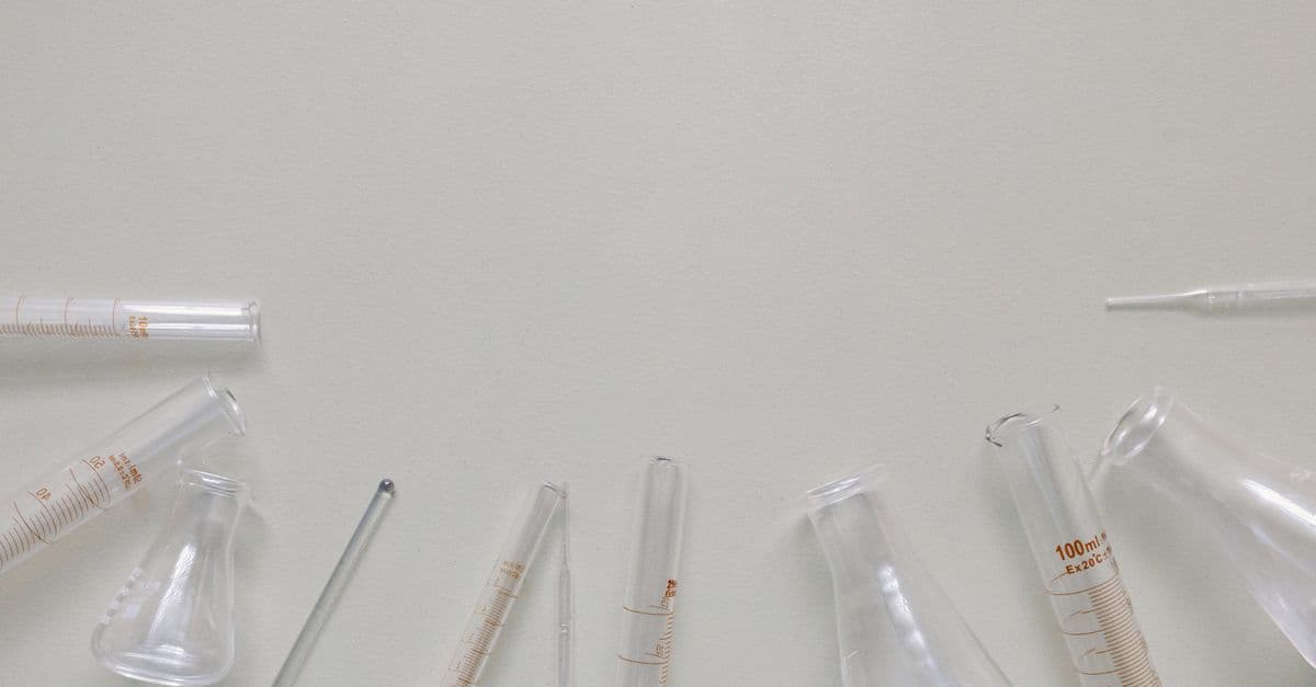 Flat lay of laboratory glassware including beakers and flasks on a neutral surface.