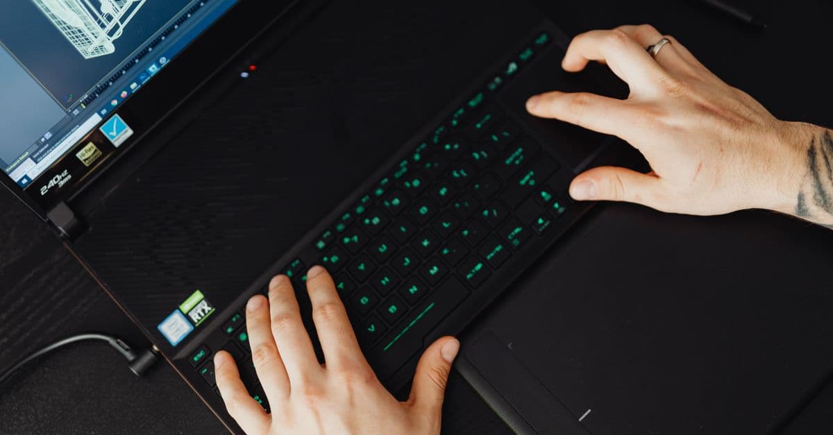 Hands typing on a laptop keyboard, ideal for tech and work themes.