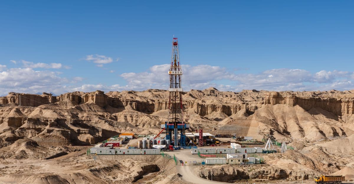 Aerial view of an oil rig amidst desert rock formations, showcasing industrial exploration.