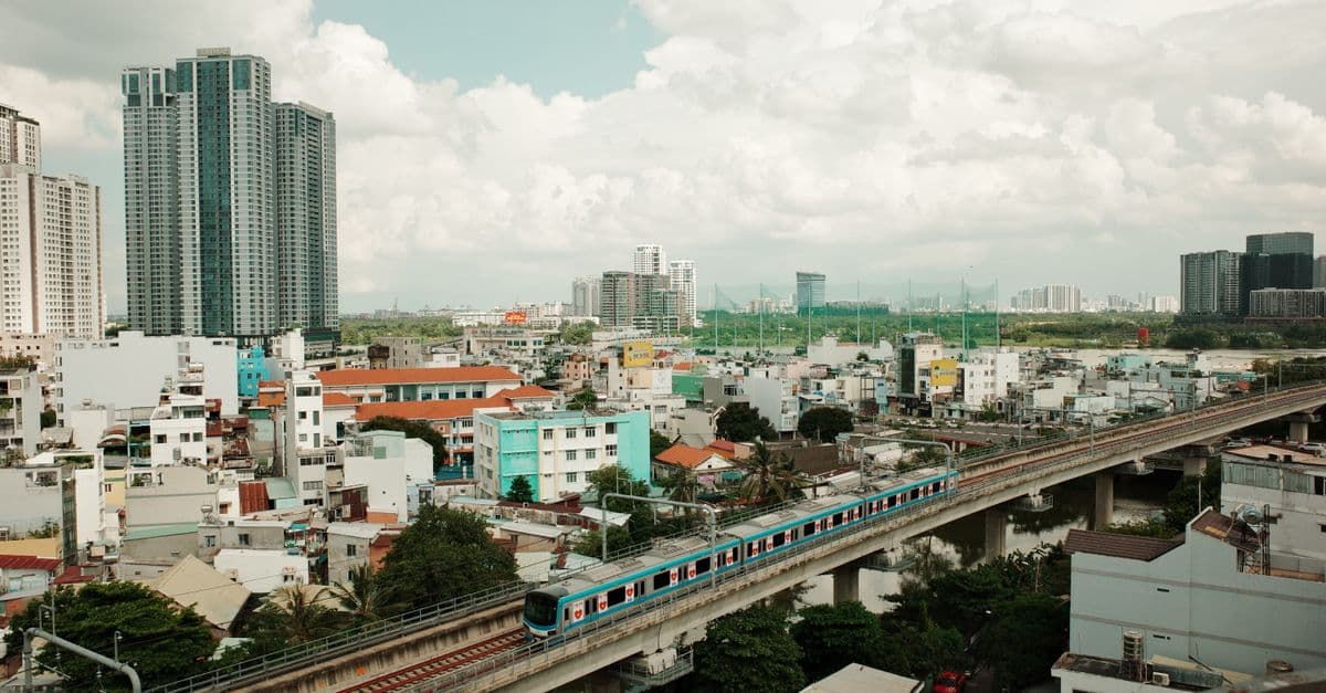 Aerial view of a modern metro train in the vibrant cityscape of Ho Chi Minh City, Vietnam.