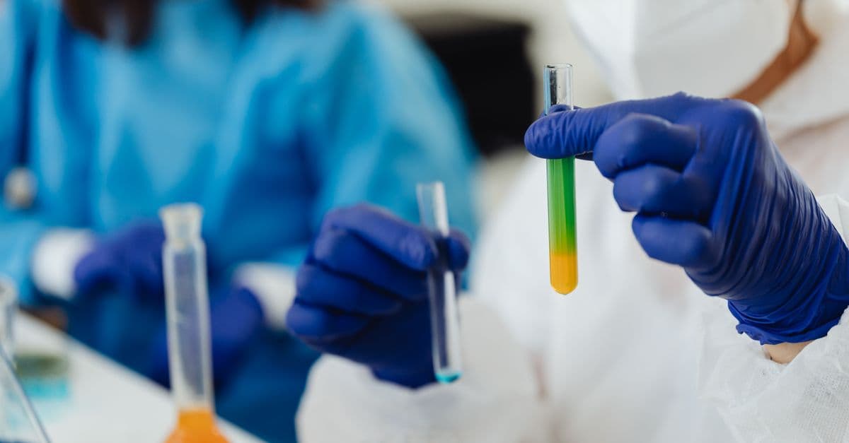 Close-up of scientists working with colorful test tubes in a laboratory setting.