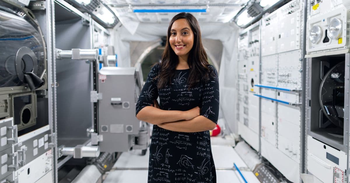 A smiling female scientist in a futuristic space station, symbolizing innovation and exploration.