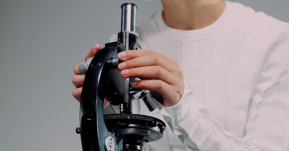 Scientist carefully using a microscope for research, close-up shot.