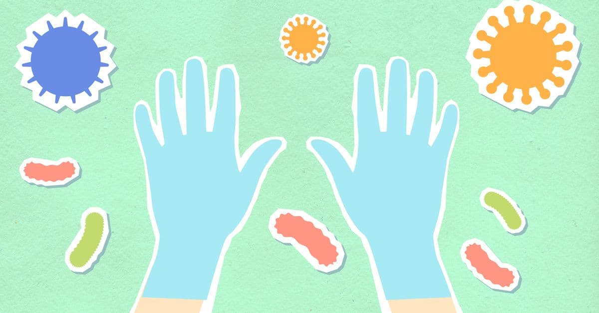 From above of decorative cardboard illustration of hands in sterile gloves among viruses and bacilli on green background