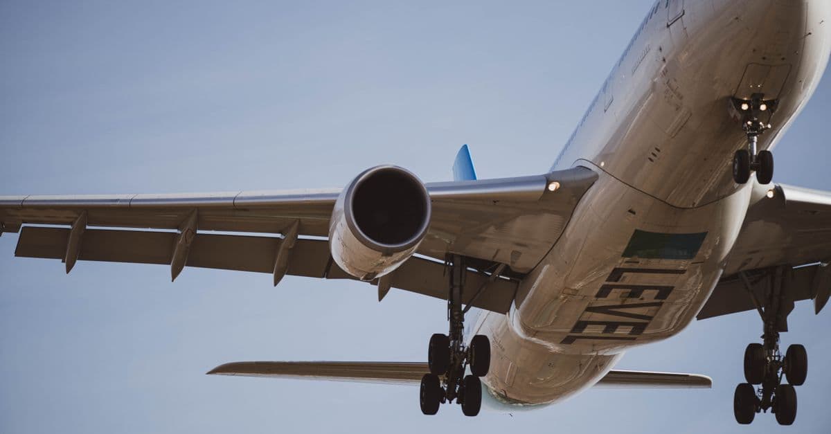 Close-up of a commercial airplane in flight preparing for landing against a clear blue sky.