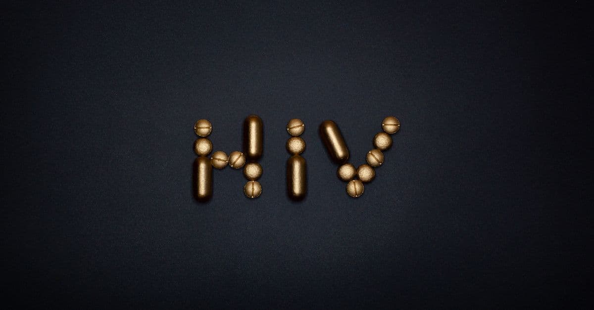 Golden capsules form the word HIV on a dark background, symbolizing healthcare and treatment.