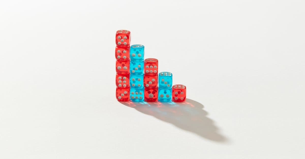 A creative arrangement of red and blue dice stacked in a descending pattern casting a shadow.