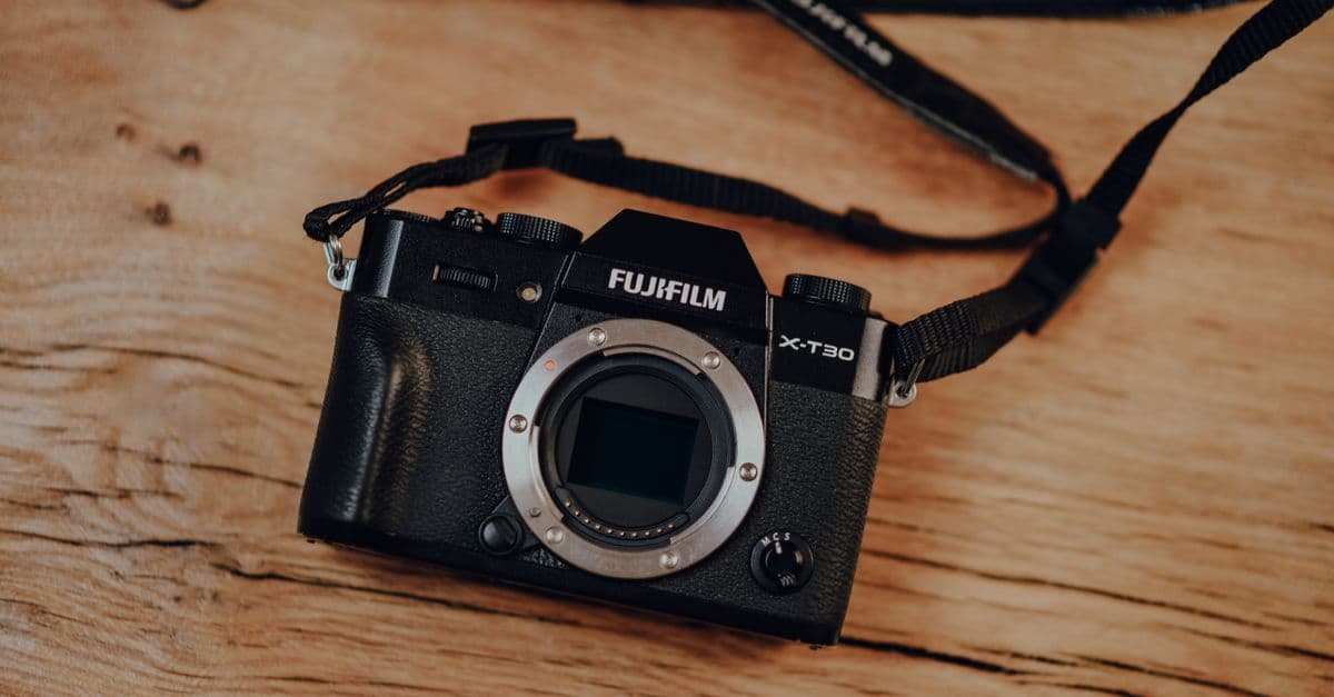Close-up of a Fujifilm X-T30 camera body resting on a wooden surface, ideal for photography enthusiasts.