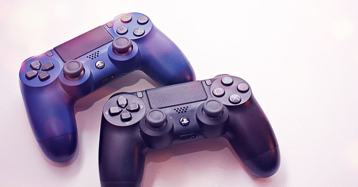 Close-up of two PlayStation controllers on a white surface, perfect for gaming themes.