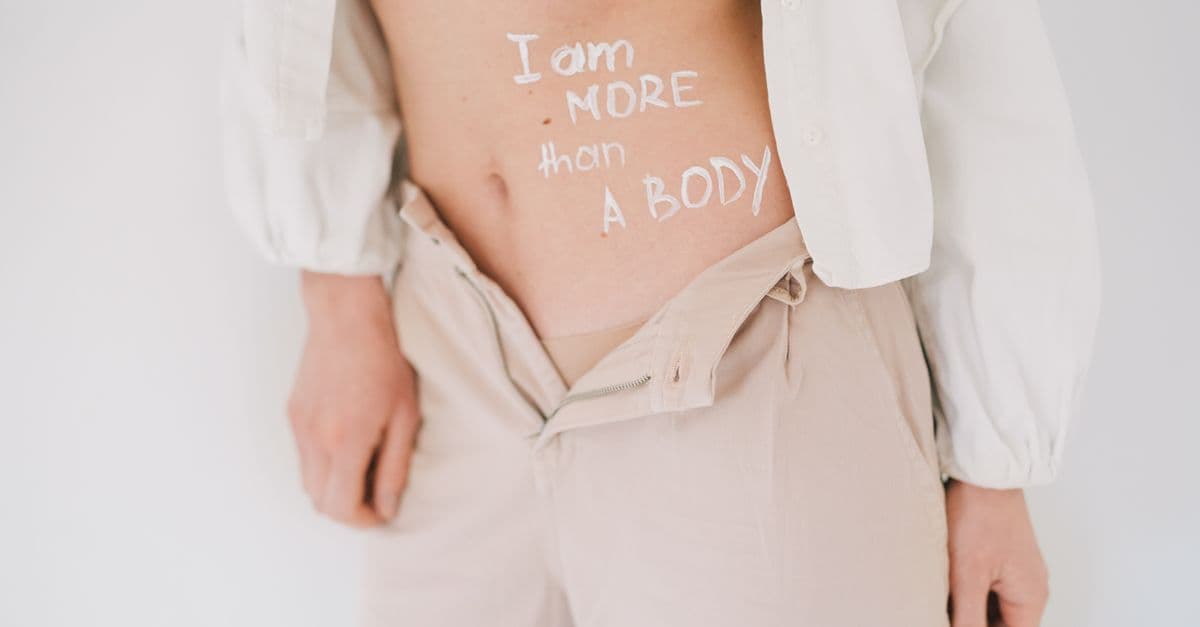 Close-up of a woman with a feminist message on her body, promoting body positivity and empowerment.