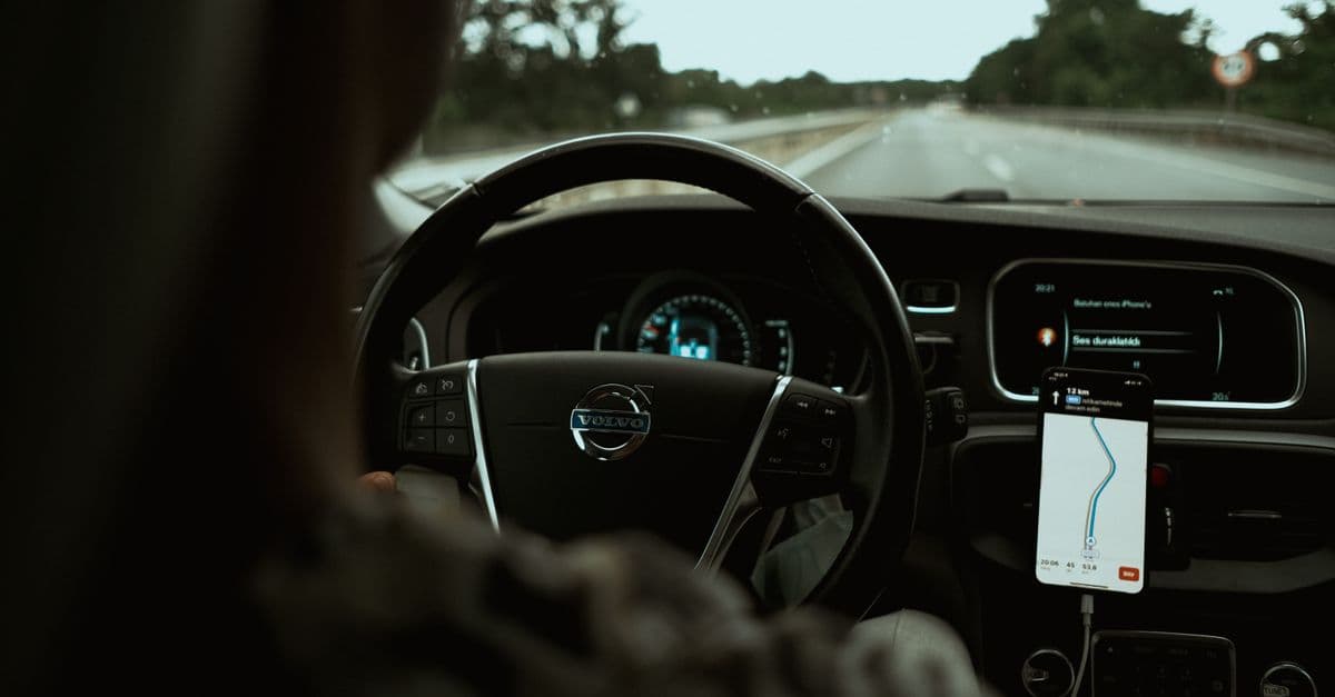 Interior view of a car on the highway using a GPS navigation app on a smartphone