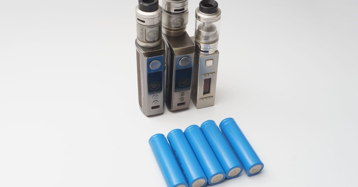 Three vape mods and six blue 18650 batteries on a white surface.