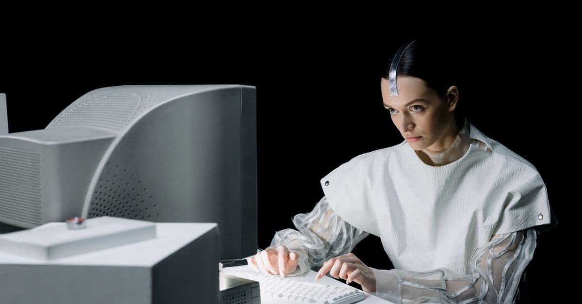 A woman in a futuristic setting working on an old computer, suggesting a blend of past and future.