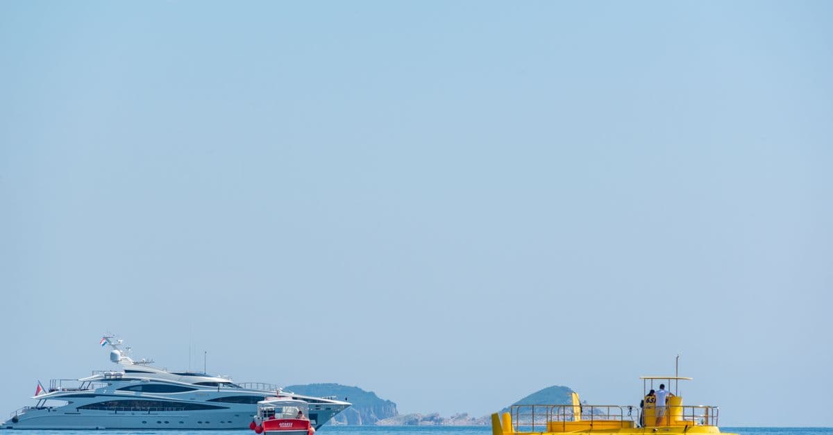 A vibrant scene of luxury yachts and a yellow submarine floating on a clear blue sea under a sunny sky.