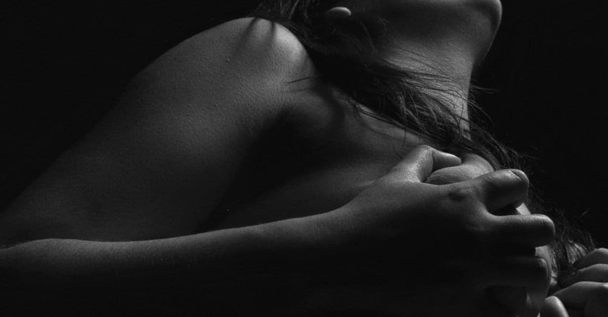 Black and white artistic portrait of a woman in a dramatic pose.