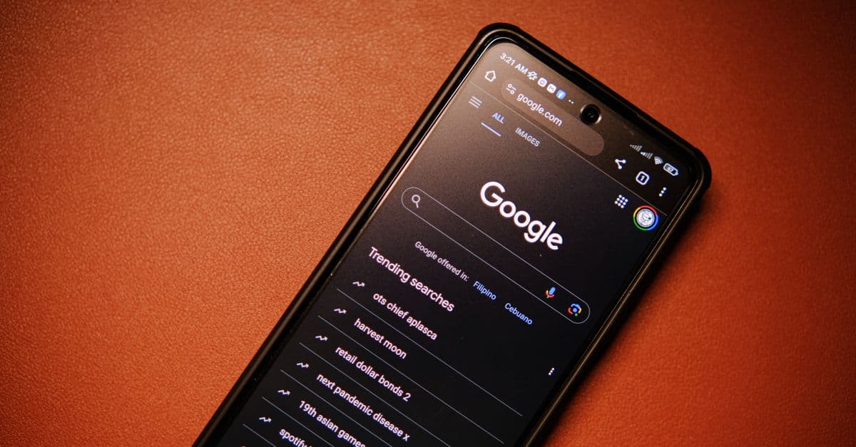 A smartphone displaying Google Search trends on a table at night.