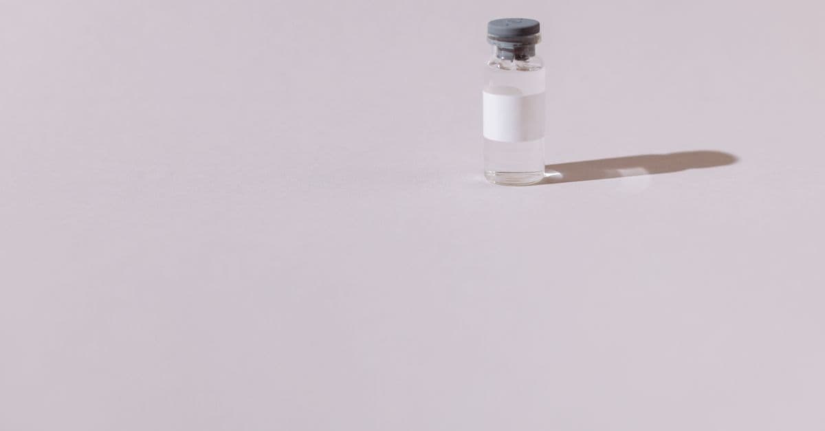 A sterile vaccine vial isolated on a minimalist gray background, emphasizing health and medicine.