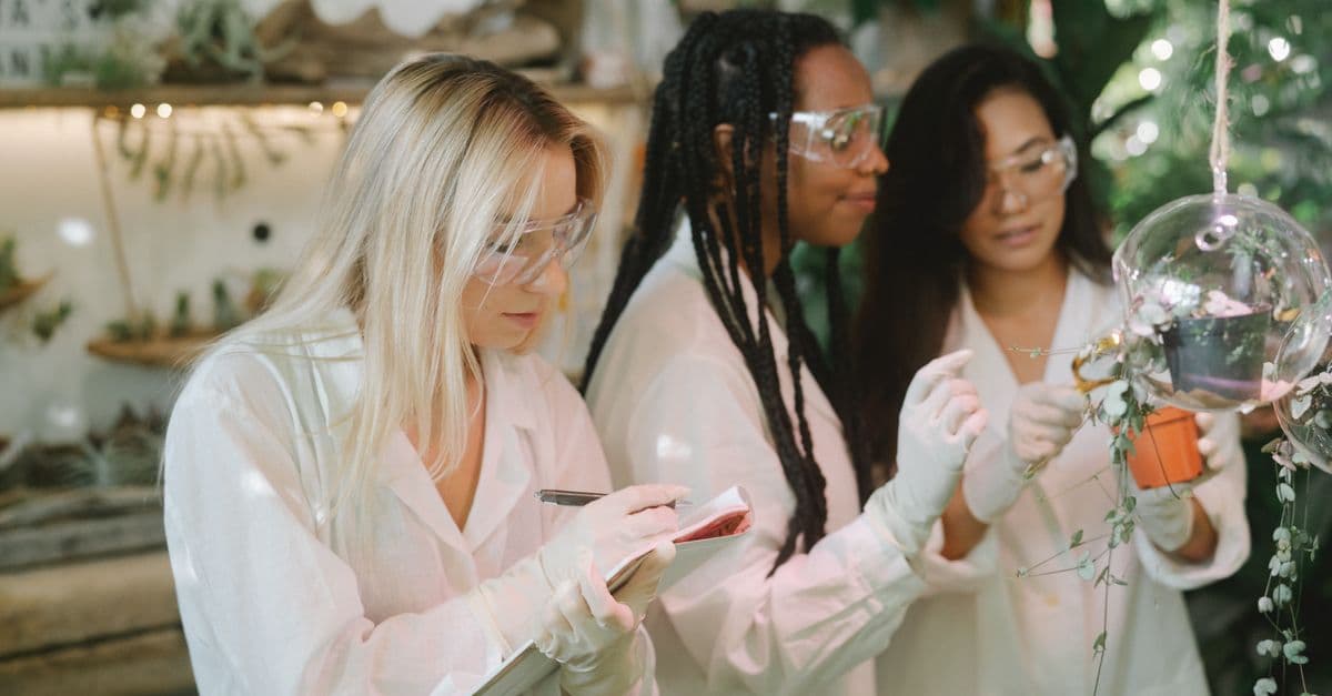 Three women scientists conducting plant research in a modern laboratory setting.