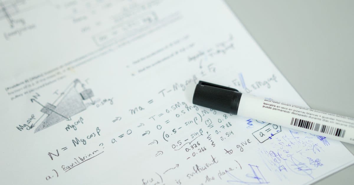 Close-up showing mathematical formulas and a marker on bond paper, ideal for education themes.