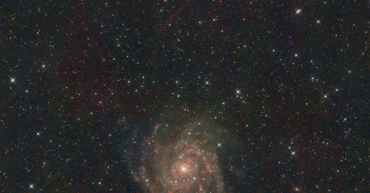 Mesmerizing view of spiral galaxy surrounded by stars in deep space, highlighting the universe's grandeur.