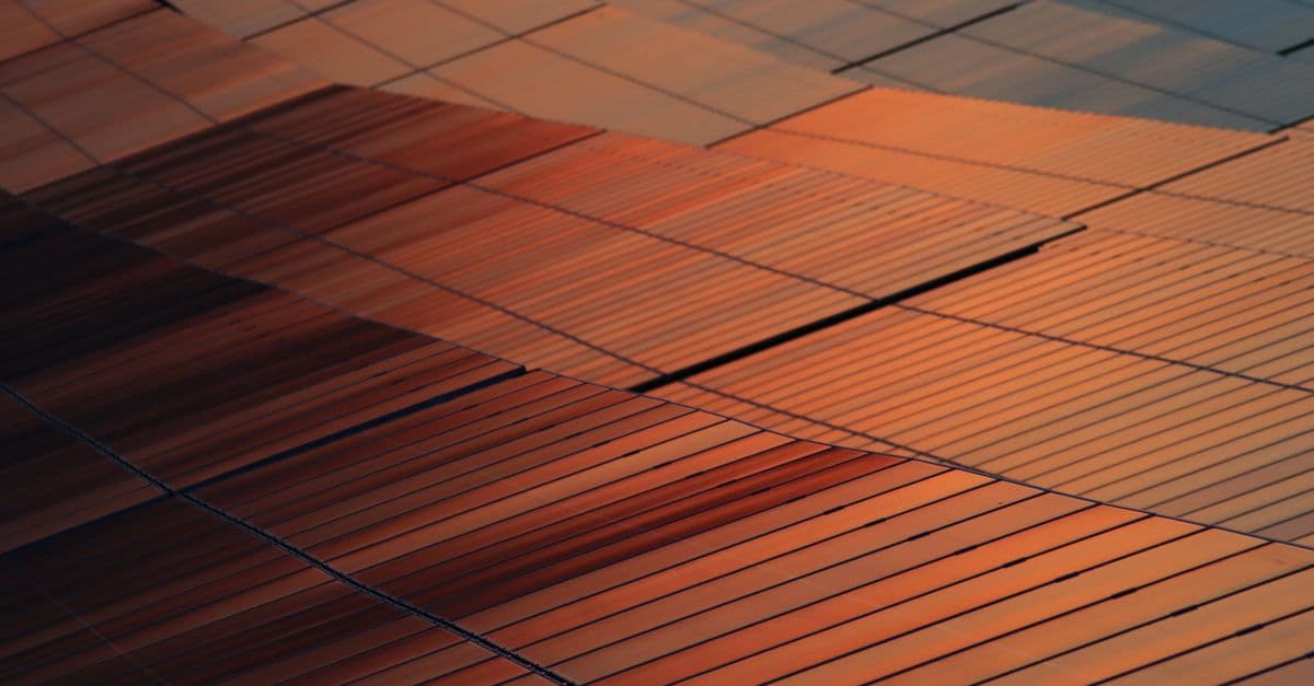 Close-up view of solar panels reflecting sunset light, illustrating renewable energy technology.