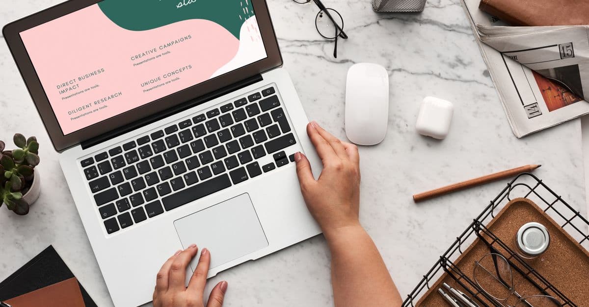 A clean office desk with a laptop showcasing creative concepts and workspace essentials.
