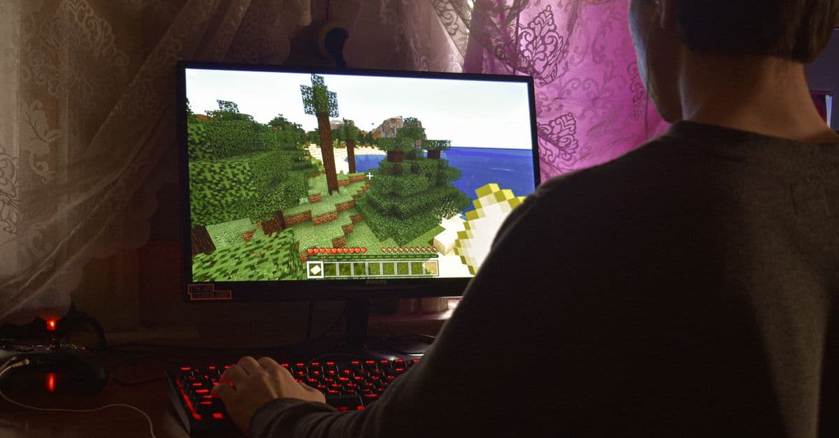 A young man intensely playing a PC video game indoors. Capturing the essence of technology and concentration.