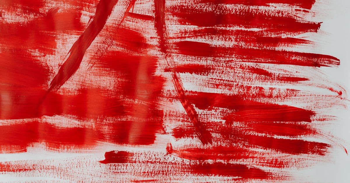 Dynamic abstract artwork featuring bold red brushstrokes on a textured canvas.