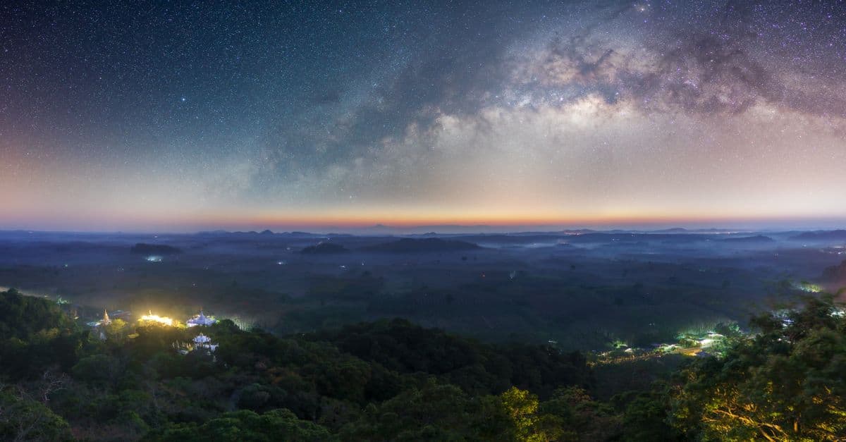 Captivating view of the Milky Way over Tambon Ton Yuan's lush landscape at night.