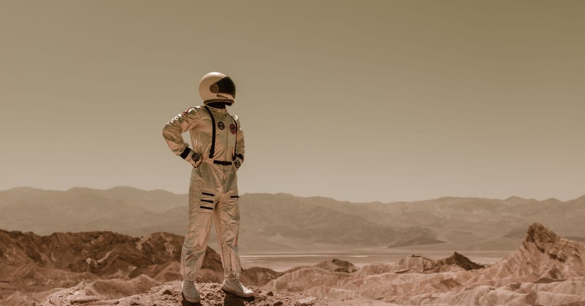 Astronaut standing in a desolate landscape, evoking sci-fi exploration on another planet.