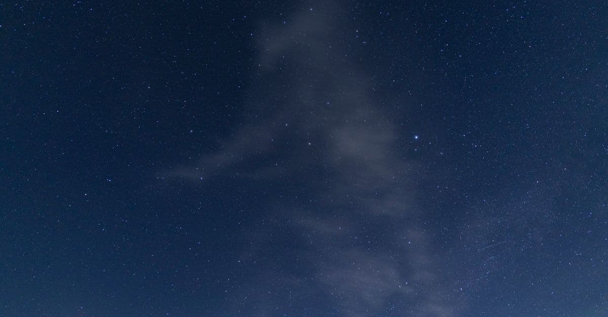 A serene view of a starry night sky with faint clouds, capturing the peacefulness of space.