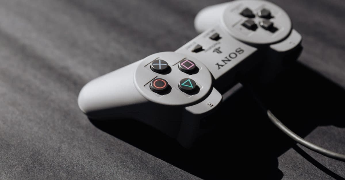Retro Sony game controller with classic buttons on a textured dark surface, showcasing vintage electronics.