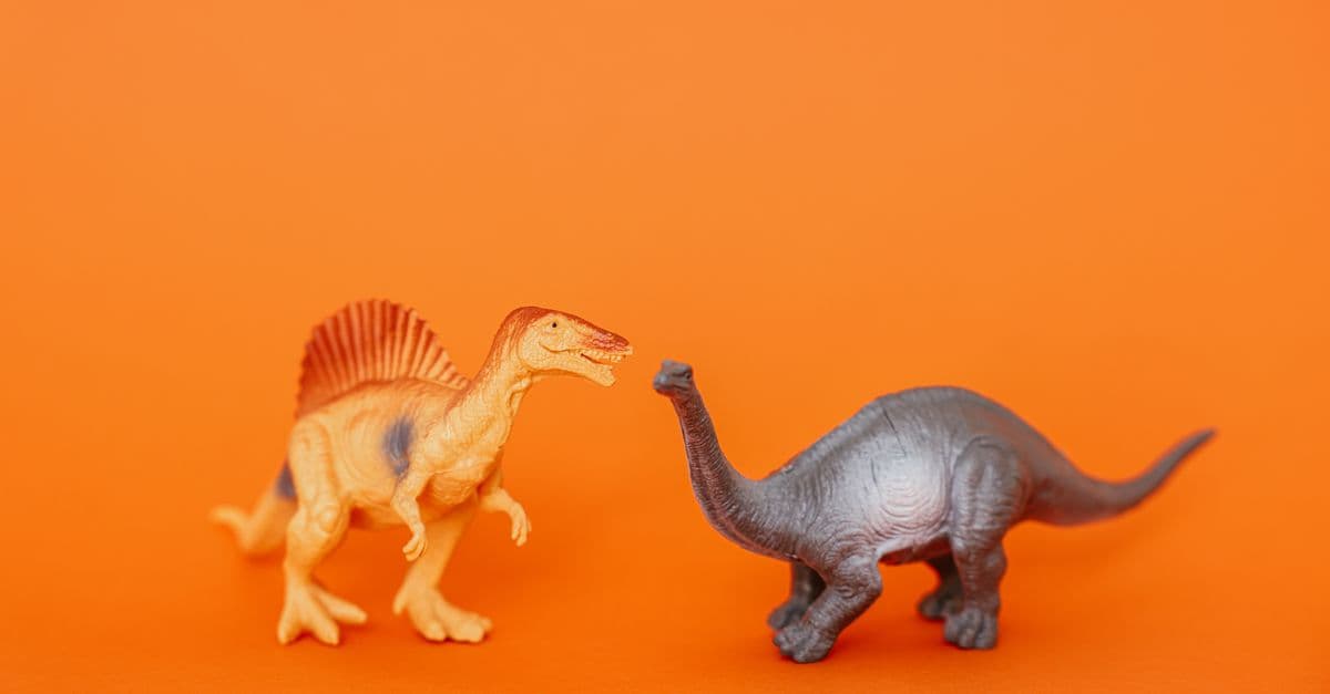 Miniature dinosaur toys in an orange setting showcasing prehistoric creatures.