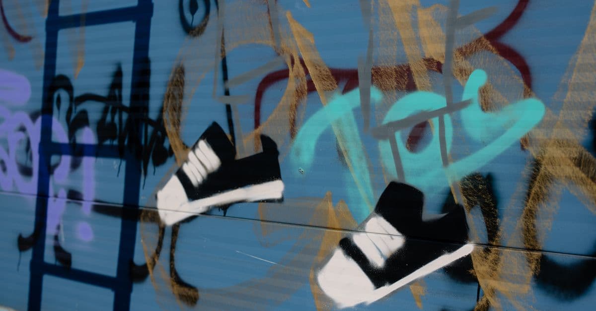 Vibrant street art depicting sneakers on a blue wall with various colors and abstract shapes.