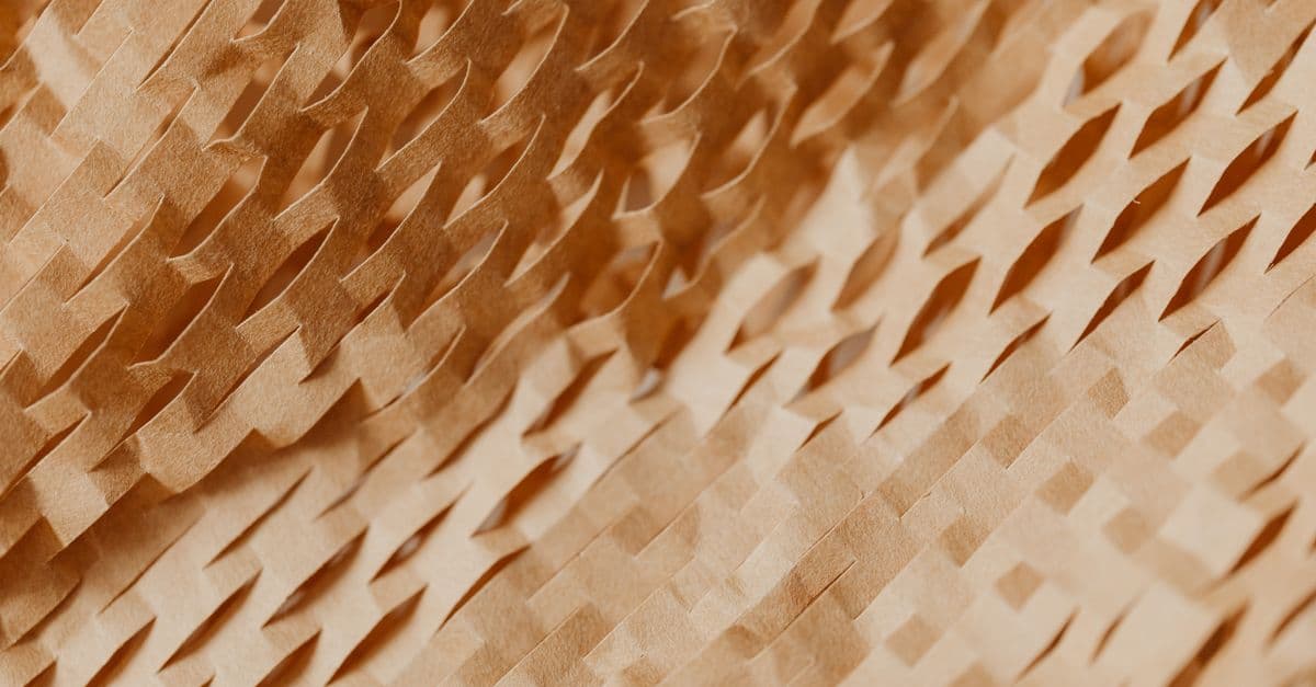 Close-up of a textured, abstract pattern in beige paper, creating a warm, artistic visual.