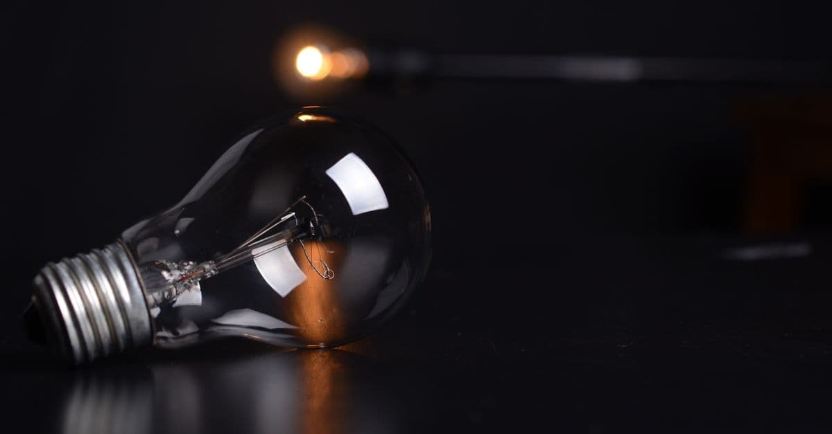 Detailed shot of a reflective light bulb on a dark background, showcasing lighting and reflections.