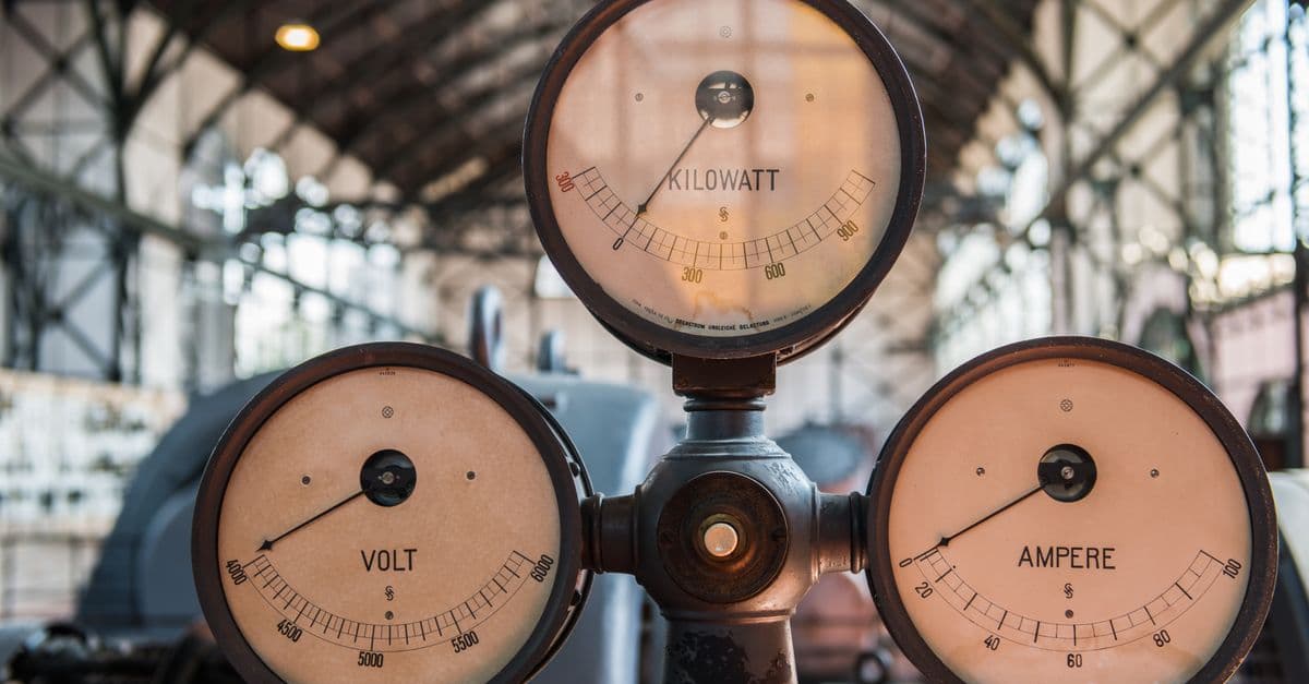 Close-up of vintage kilowatt, volt, and ampere gauges in Essen's industrial setting.