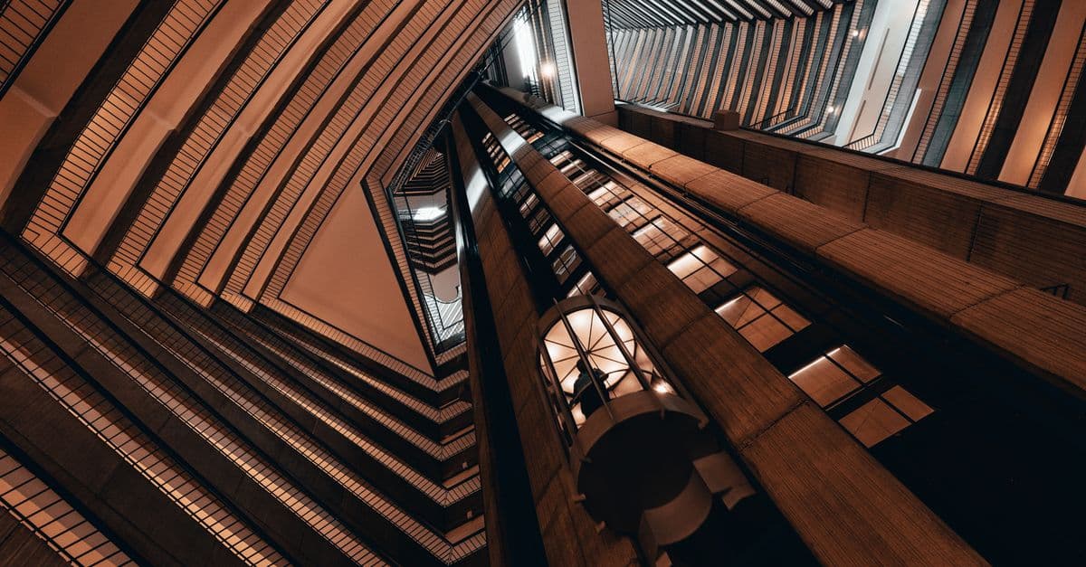 Striking low angle view of a contemporary building interior with elevators, showcasing modern architectural lines.