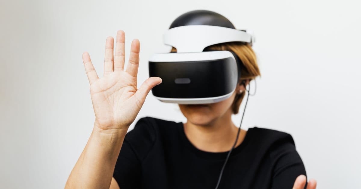 Woman experiencing virtual reality with VR headset on white background.