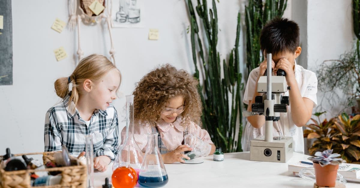 Diverse group of children engaged in science experiments in a classroom laboratory setting.