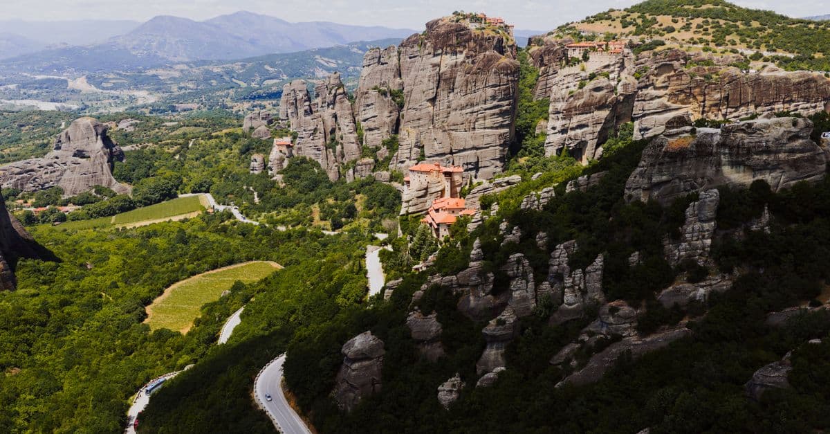 Aerial view of the iconic Meteora monasteries amidst rocky mountains in Greece.