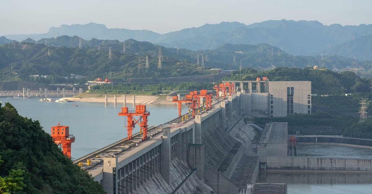 A breathtaking aerial view of the Three Gorges Dam surrounded by mountains, emphasizing its massive scale.